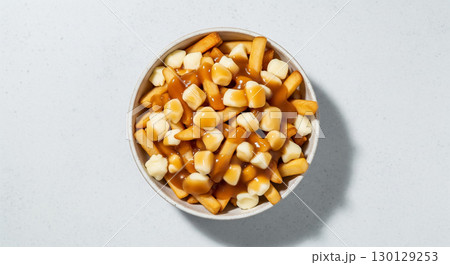 A Top Down View of a Bowl of Canadian Poutine on a White Background 130129253