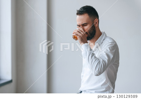 Upset young man drinker alcoholic is indoors Upset young man drinker alcoholic is indoors 130129389
