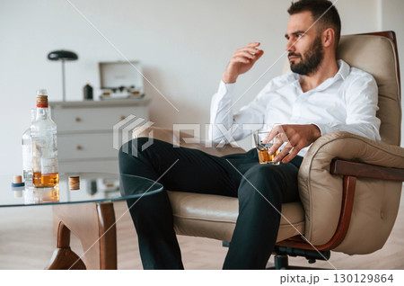 Feeling depressed. Upset young man drinker alcoholic is indoors Feeling depressed. Upset young man drinker alcoholic is indoors 130129864
