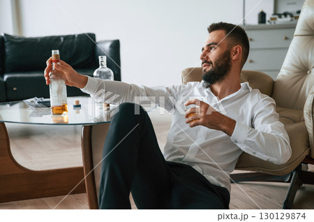 Feeling depressed. Upset young man drinker alcoholic is indoors 130129874