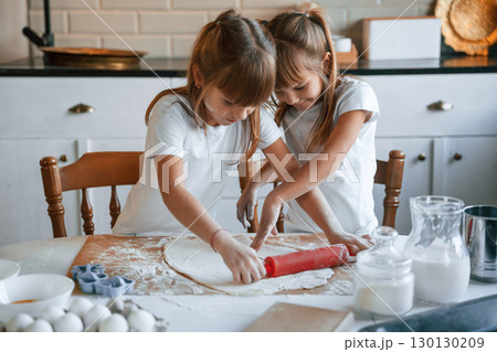 Dough on the table. Two little girls are preparing food on the kitchen 130130209