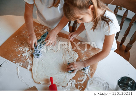 Dough on the table. Two little girls are preparing food on the kitchen Dough on the table. Two little girls are preparing food on the kitchen 130130211