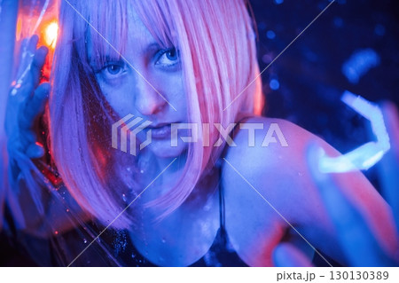 Focused close up view. Stylish woman with white hair is behind wet transparent plastic sheet Focused close up view. Stylish woman with white hair is behind wet transparent plastic sheet 130130389