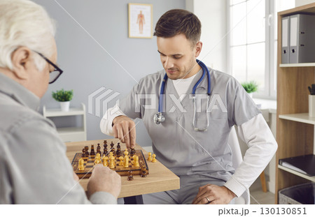 Nurse man playing chess game with a senior person in clinic or in retirement home. Nurse man playing chess game with a senior person in clinic or in retirement home. 130130851