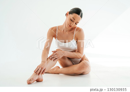 Clean legs after depilation. Woman in white underwear with slim body type against white background Clean legs after depilation. Woman in white underwear with slim body type against white background 130130935