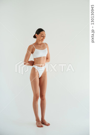 Weight loss conception. Woman in white underwear with slim body type against white background 130130945