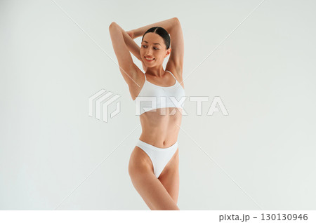 Weight loss conception. Woman in white underwear with slim body type against white background 130130946