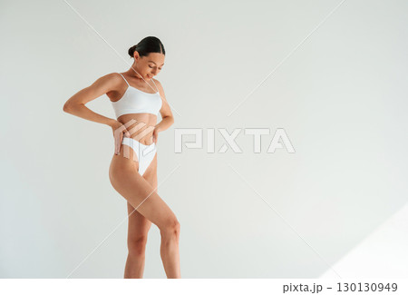 Results of diet and healthy eating. Woman in white underwear with slim body type against white background 130130949