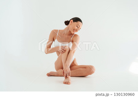 Clean legs after depilation. Woman in white underwear with slim body type against white background Clean legs after depilation. Woman in white underwear with slim body type against white background 130130960