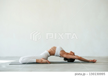 Fitness woman is indoors in white clothes 130130995