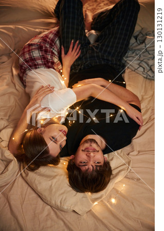 View from behind, lying down on bed. Couple celebrating New Year together 130131219