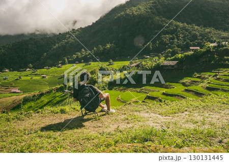 ecology travel with man solo travel and camping outdoor relax in rice field at chiangmai thailand in raining season 130131445