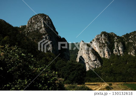 Majestic rocky peaks rising above dense green forest under a clear blue sky in Stara Planina, Serbia 130132618