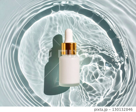 A glass dropper bottle on water surface, top view A glass dropper bottle on water surface, top view 130132846