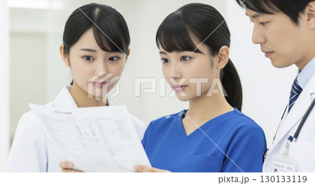 男性医師と書類を確認する女性看護師 男性医師と書類を確認する女性看護師 130133119