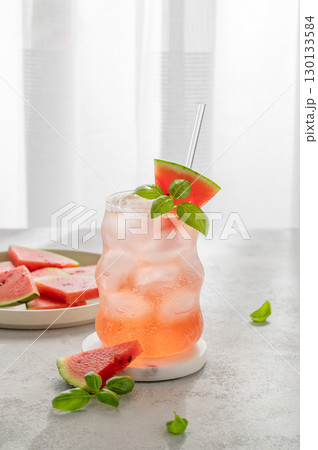 Watermelon mojito cocktail with ice and mint in a glass on a light table near window Watermelon mojito cocktail with ice and mint in a glass on a light table near window 130133584