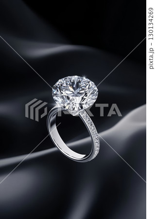 A stunning diamond ring gracefully floats in the air, exhibiting its exquisite brilliance against a smooth dark backdrop, perfect for elegance A stunning diamond ring gracefully floats in the air, exhibiting its exquisite brilliance against a smooth dark backdrop, perfect for elegance 130134269