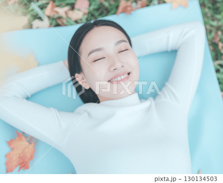 気持ちよさそうに寝転ぶ女性 気持ちよさそうに寝転ぶ女性 130134503