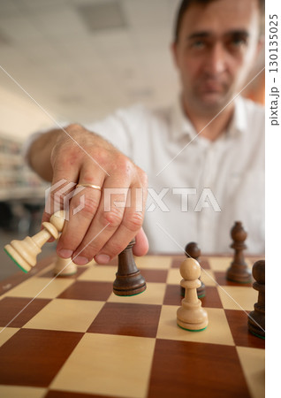 Middle aged Caucasian man playing chess. Middle aged Caucasian man playing chess. 130135025
