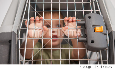 A small child in a closed cage. A small child in a closed cage. 130135085