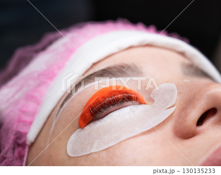 Caucasian woman undergoing eyelash lamination procedure. Caucasian woman undergoing eyelash lamination procedure. 130135233