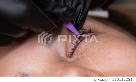 The process of professional eyelash lamination in a salon.  130135251