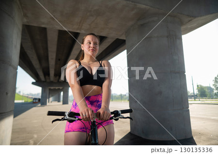 Caucasian woman in short shorts riding a bicycle. Caucasian woman in short shorts riding a bicycle. 130135336