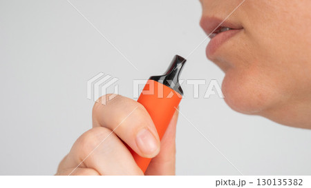 Caucasian woman smoking disposable vape.  130135382