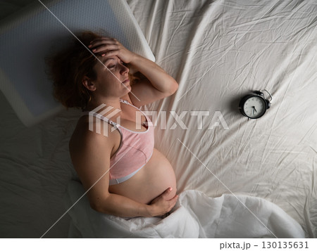 Pregnant woman suffers from pain at night. Pregnant woman suffers from pain at night. 130135631