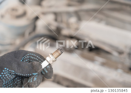 Caucasian man changing spark plugs in car. Caucasian man changing spark plugs in car. 130135845