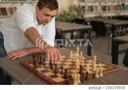 Caucasian man thinking about a chess move. Caucasian man thinking about a chess move. 130135858