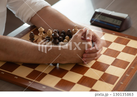 Close up of hands of middle aged caucasian man playing chess.  130135863