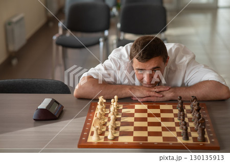Middle aged Caucasian man playing chess. Middle aged Caucasian man playing chess. 130135913
