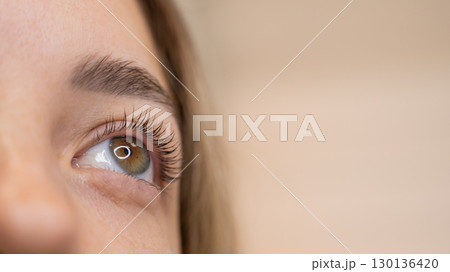 Close-up of a woman's eye after eyelash lamination procedure. Close-up of a woman's eye after eyelash lamination procedure. 130136420