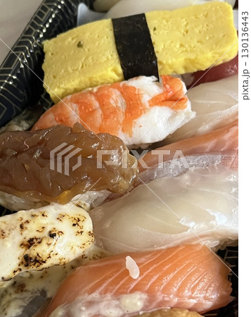 An assortment of fresh sushi, artfully arranged with a variety of toppings and vibrant colors. This traditional Japanese dish combines vinegared rice, seafood, and vegetables for an experience. 130136443