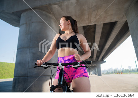 Caucasian woman in short shorts riding a bicycle. Caucasian woman in short shorts riding a bicycle. 130136664