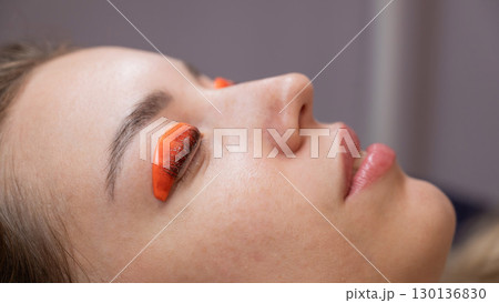 Caucasian woman undergoing eyelash lamination procedure. Caucasian woman undergoing eyelash lamination procedure. 130136830