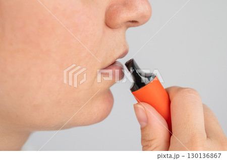 Caucasian woman smoking disposable vape. Caucasian woman smoking disposable vape. 130136867