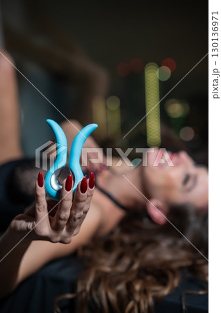 Woman using blue clitoral vibrator.  130136971