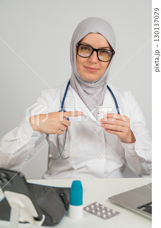 Female doctor in hijab recommends medications.  130137079