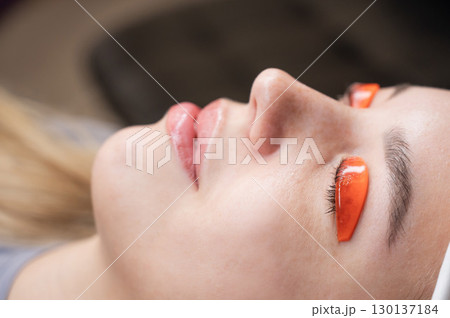 Caucasian woman undergoing eyelash lamination procedure.  130137184