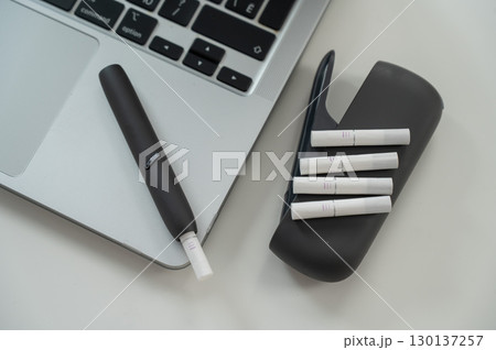 Tobacco heating system next to a laptop.  130137257