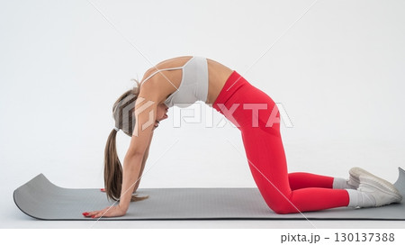 Caucasian woman doing sports exercises on white background.  130137388
