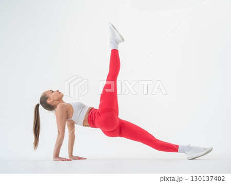 Caucasian woman doing sports exercises on white background.  130137402