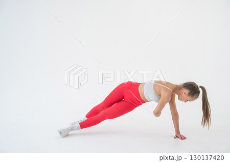 Young woman doing side plank and twists on white background. Young woman doing side plank and twists on white background. 130137420