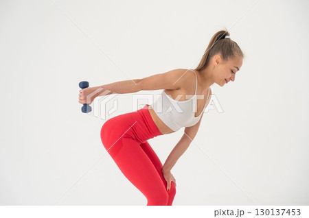 Young woman doing exercise with dumbbells on white background. Young woman doing exercise with dumbbells on white background. 130137453