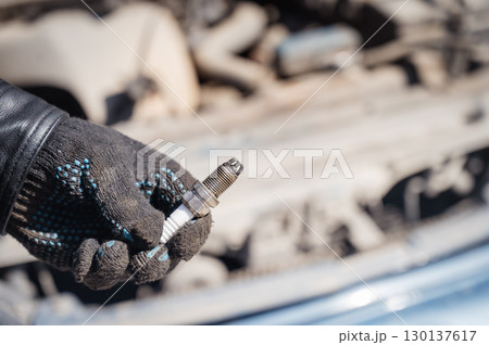 Caucasian man changing spark plugs in car.  130137617