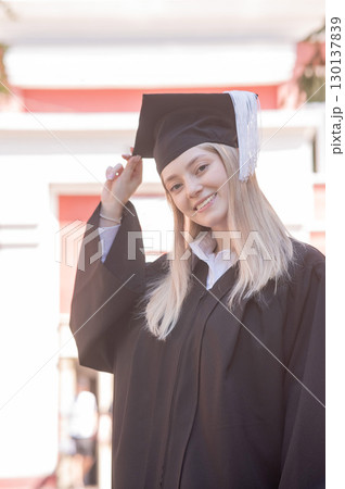 Portrait of a young Caucasian woman in a graduation gown. Portrait of a young Caucasian woman in a graduation gown. 130137839