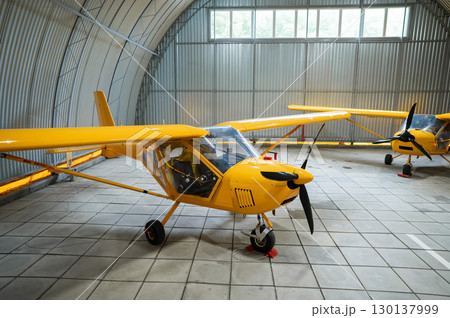 Yellow airplane glider in the hangar.  130137999