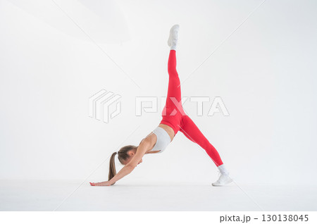 Caucasian woman doing sports exercises on white background.  130138045